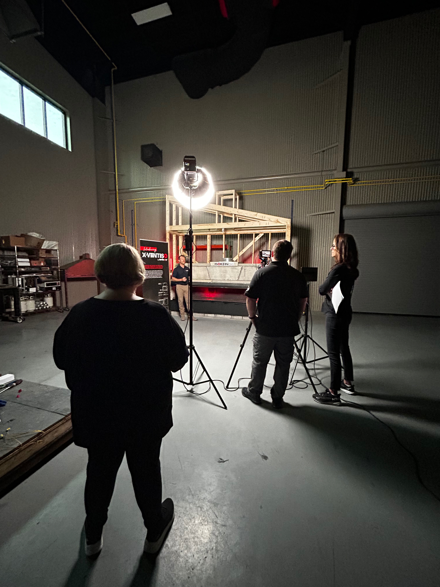 Production team lighting a demonstration shoot with a ring light on set