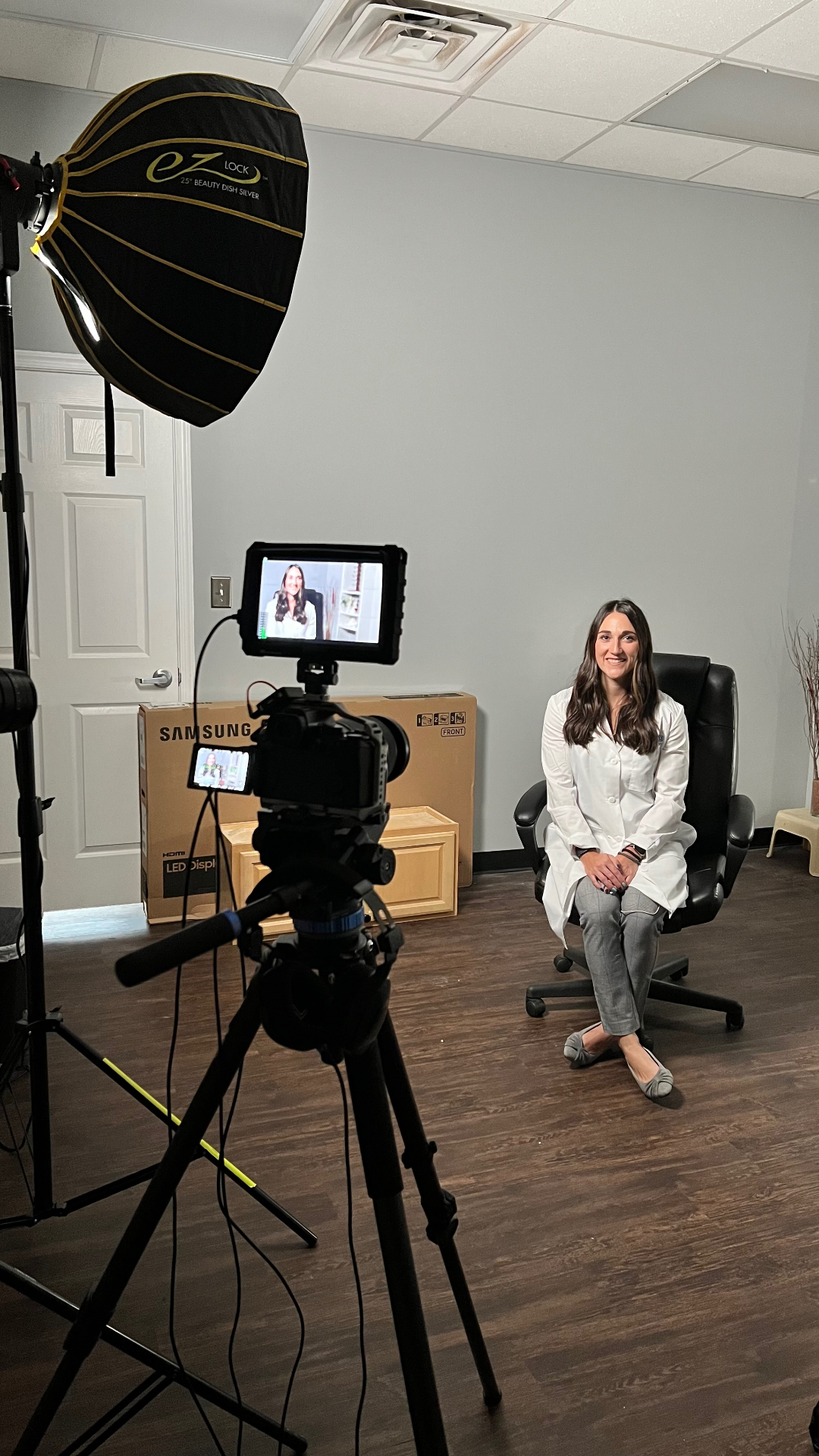 Interview setup with a beauty dish softbox and camera monitor at a client office